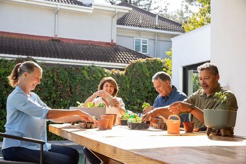 Senior Friends Enjoy Bonding over Gardening on Sunny Patio