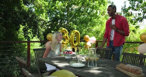 Couple Celebrating 30th Birthday in Garden with Balloons