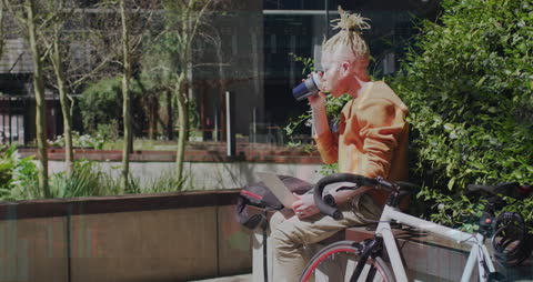 Man Relaxing Outdoors with Laptop and Beverage