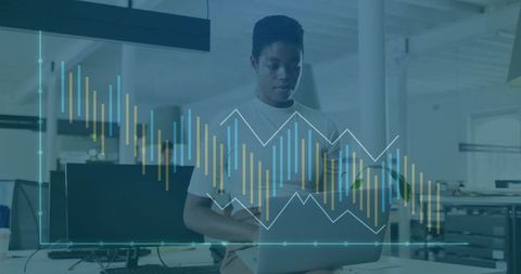 Working woman using laptop in modern office with data analytics