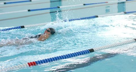 Competitive Female Swimmer Performing Freestyle in Indoor Pool - Download Free Stock Images Pikwizard.com