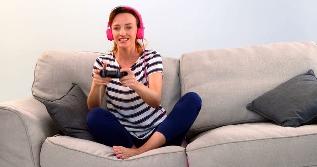 Woman Playing Video Games with Headphones On Modern Couch - Download Free Stock Images Pikwizard.com