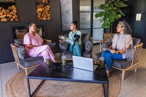 Diverse healthcare women recording podcast and discussing wellness in cozy lounge