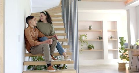 Romantic Couple Relaxing on Modern Staircase Indoors