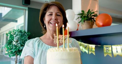 Joyful Woman Holding Cake with Candles at Birthday Celebration