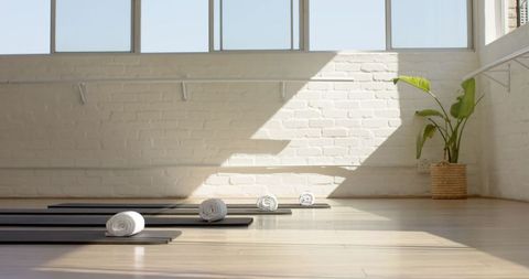 Bright Sunlit Yoga Studio with Rolled Mats and Towels - Download Free Stock Images Pikwizard.com