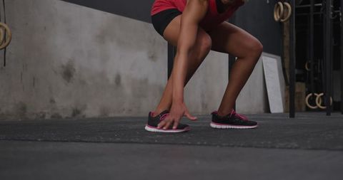 Woman squatting in gym focusing on strength training