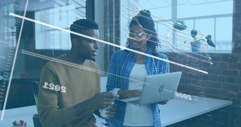 Tech Professionals Analyzing Data on Laptop in Office