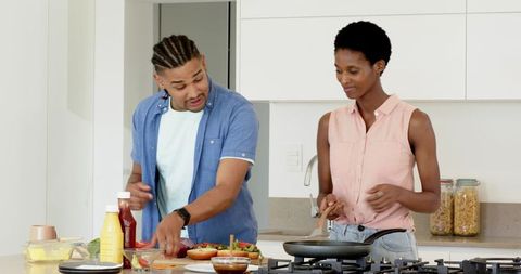 Diverse Couple Cooking Burgers Together in Modern Kitchen