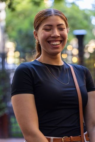 Smiling african american woman enjoying evening in city park with bokeh lights