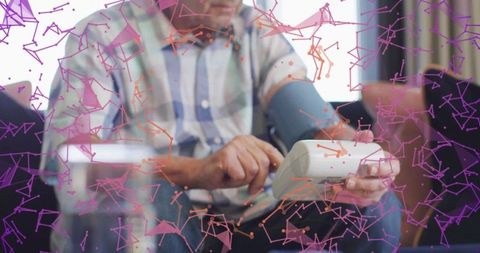 Elderly man using blood pressure monitor with futuristic graphics