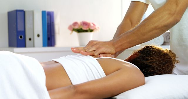 A professional massage therapist is providing a relaxing treatment to a Caucasian woman, with copy space. Capturing a moment of wellness, the image reflects the therapeutic benefits of massage in a serene setting.