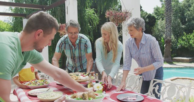 Happy caucasian family setting the table together in garden. Lifestyle, domestic life, family, and togetherness.