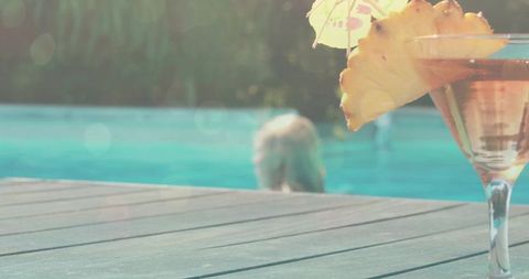 Tropical Cocktail Glass by Poolside with Pineapple Slice and Umbrella