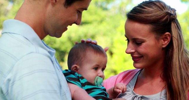 Loving Parents Holding Baby Outdoors in Park - Download Free Stock Images Pikwizard.com