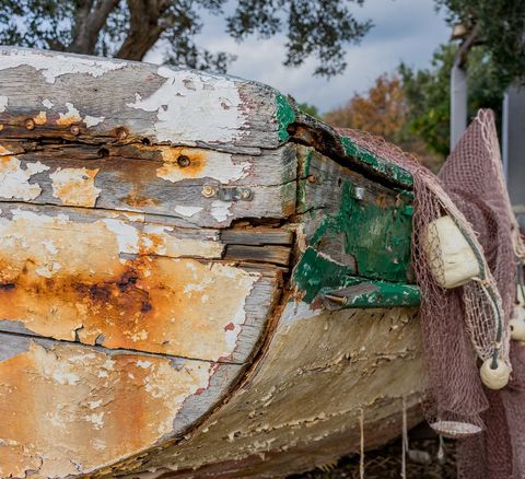 Weathered fishing boat with peeling paint and nets