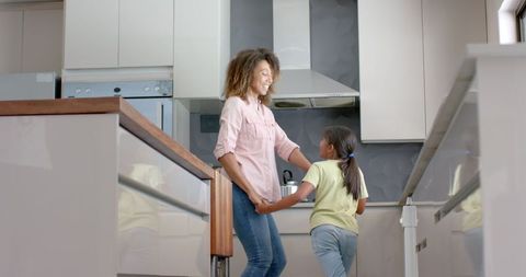 Joyful Family Moment: Mother and Daughter Dancing in Kitchen