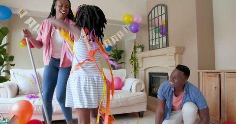 Family Clearing Living Room After Joyful Birthday Celebration