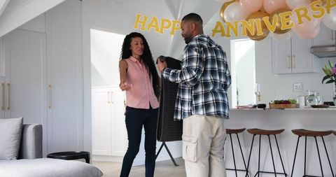 Couple tidying up after joyous anniversary celebration home