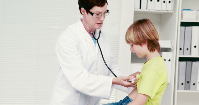 A Caucasian female doctor is checking the blood pressure of a young Caucasian boy in a clinical setting, with copy space. It illustrates a routine pediatric health check-up, emphasizing the importance of regular medical assessments for children.