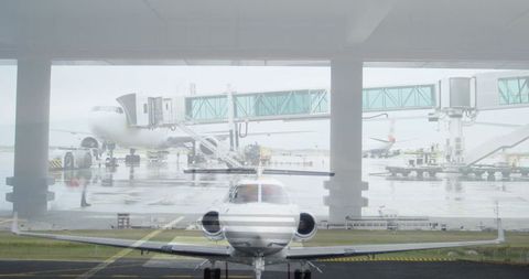 Modern Aircraft on Runway with Jet Bridges at Rainy Airport