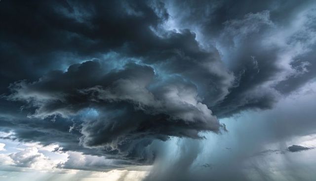 Roaring cumulonimbus forming over open plain, casting dramatic rain shafts and virga