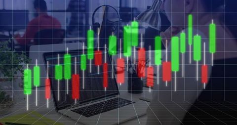 Laptop displaying live candlestick charts in modern corporate workspace