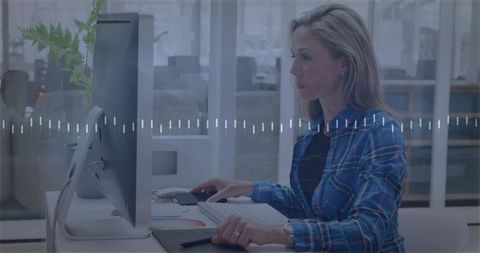 Professional woman using graphics tablet at modern office desk