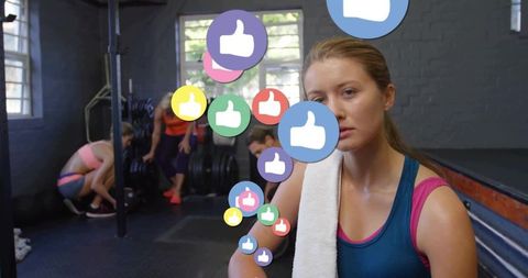 Trainee Relaxing on Bench with Digital Engagement Icons in Gym