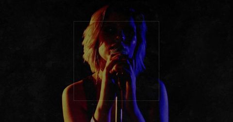 Dramatic singer illuminated by red and blue stage lights