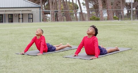 Two Young Boys Practicing Yoga Outdoors During Exercise
