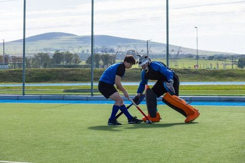Field hockey players competing on outdoor turf field