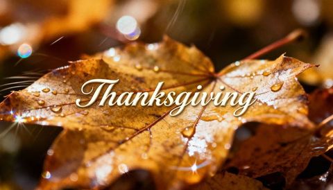 Golden maple leaf with dewdrops and Thanksgiving script, autumn bokeh closeup