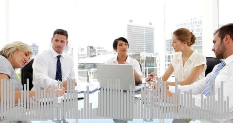 Corporate Team Collaborating Around Laptop at Glass Boardroom Table with City Skyline