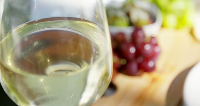 Close-Up of Glass of White Wine with Grapes in Background - Download Free Stock Images Pikwizard.com