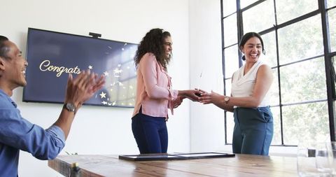 Diverse business team celebrating achievement in meeting room