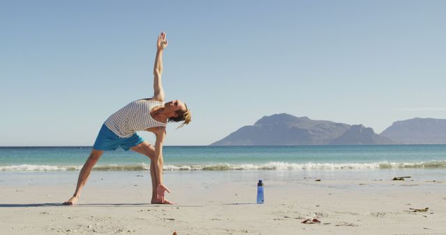 Man Practicing Yoga on Beach by Ocean and Mountains - Download Free Stock Images Pikwizard.com