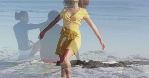 Woman walking and balancing on beach in yellow wrap dress with surf friends overlay