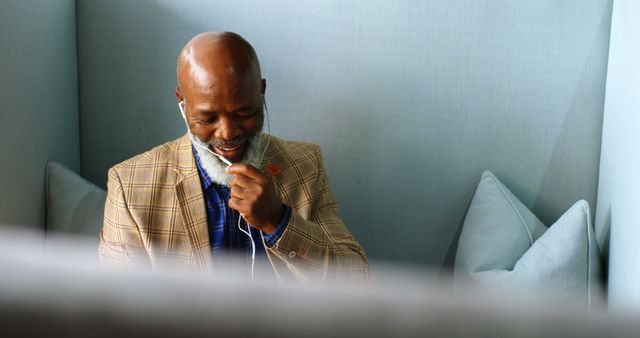 Mature Man Wearing Earphones and Relaxing on Cushioned Seat - Download Free Stock Images Pikwizard.com