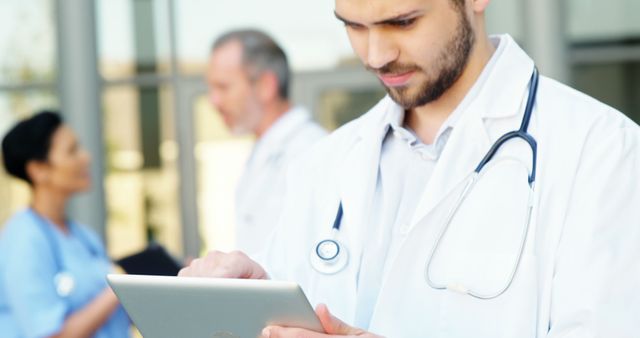 Healthcare Professional Using Digital Tablet in Modern Medical Facility - Download Free Stock Images Pikwizard.com