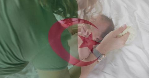 Caregiver cradling newborn on bed with turkish flag overlay symbolizing maternal bond