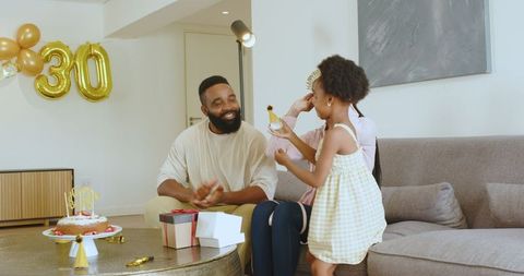 Happy multiracial family celebrating mother's birthday at home