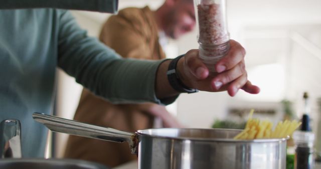 Person Adding Salt to Boiling Pasta in Modern Kitchen - Download Free Stock Images Pikwizard.com