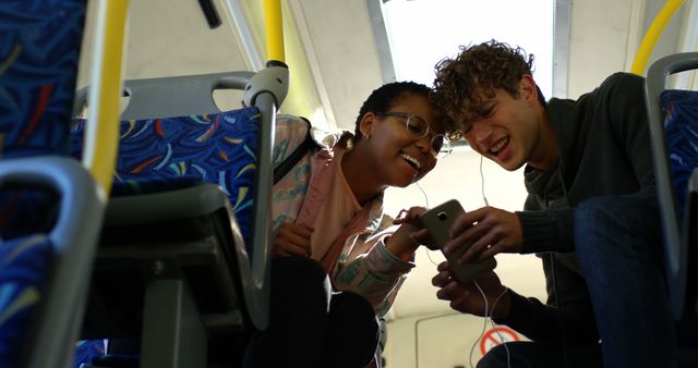 Friends Sharing Earbuds Watching Something on Phone Inside Bus - Download Free Stock Images Pikwizard.com