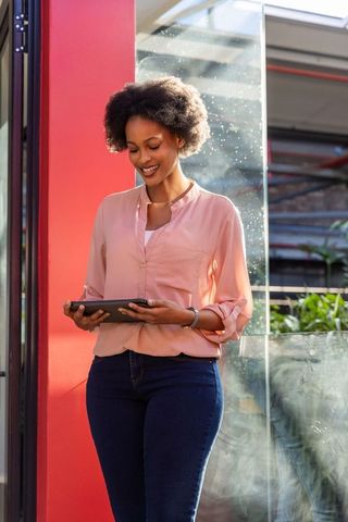 Professional Woman Holding Tablet in Modern Office Environment