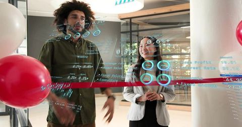 Diverse team presenting holographic data on glass wall during office celebration and demo