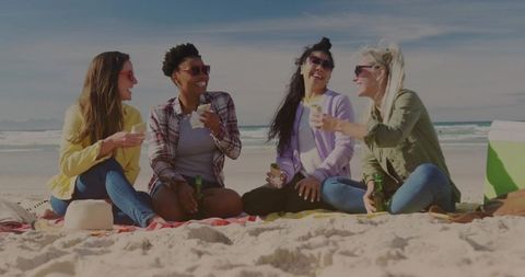Group of friends enjoying day at beach with snacks and drinks