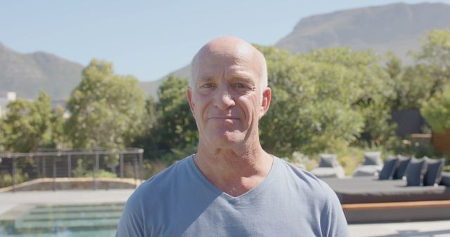 Mature Man Enjoying Outdoor Poolside Garden on a Bright Day - Download Free Stock Images Pikwizard.com