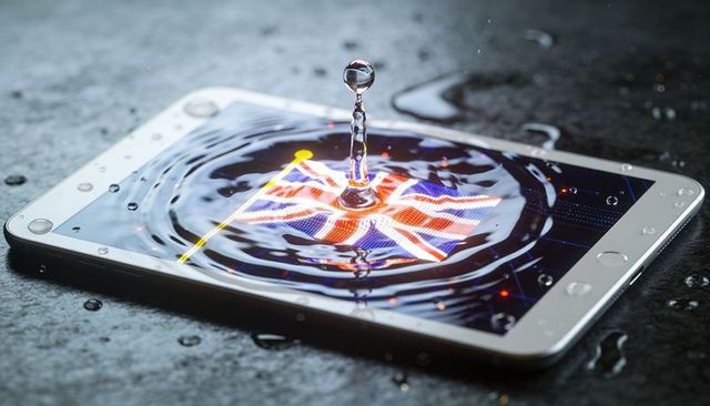 Tablet Displaying Distorted Union Jack with Dramatic Water Droplet and Ripples, Closeup
