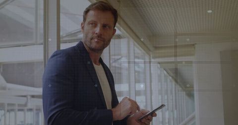 Business traveler navigating smartphone in airport terminal